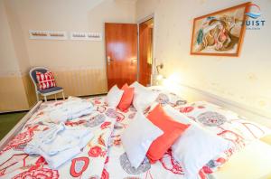 a bedroom with a large bed with colorful pillows at Haus Petra 132 - Ferienwohnung 2 in Juist