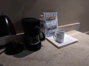 una cafetera y una taza en un mostrador en EXECUTIROOMS VERACRUZ en Veracruz