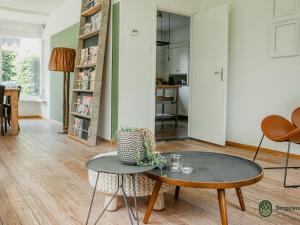 a living room with a coffee table and a kitchen at Majestic, large holiday home near Leende, detached and located between meadows and forests in Leende