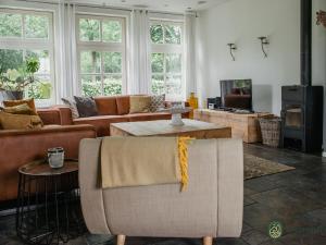 a living room with a couch and a table at Luxurious holiday home in the middle of the Leenderbos nature reserve, near quiet Leende in Leende