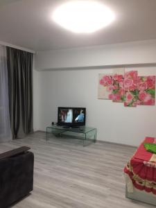 een woonkamer met een flatscreen-tv en een bank bij Квартира Юбилейный in Alma-Ata