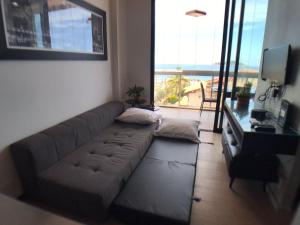 a living room with a couch and a television at Maravilhoso Loft vista mar OCEANVIEW in Niterói