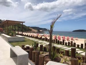 a beach with chairs and umbrellas and the ocean at Maravilhoso Loft vista mar OCEANVIEW in Niterói