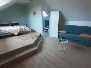 聖倫納德·德博的住宿－Gîte Saint-Léonard-des-Bois, 6 pièces, 12 personnes - FR-1-410-355，一间卧室配有一张床和一张蓝色的沙发
