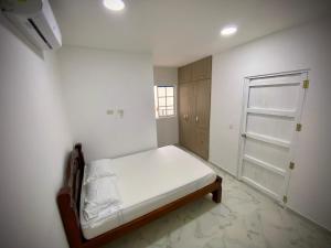 biała sypialnia z łóżkiem i drzwiami w obiekcie Cómoda y linda casa en mompox w mieście El Socorro