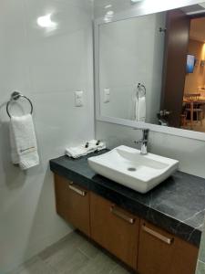 La salle de bains est pourvue d'un lavabo et d'un grand miroir. dans l'établissement EXECUTIROOMS VERACRUZ, à Veracruz