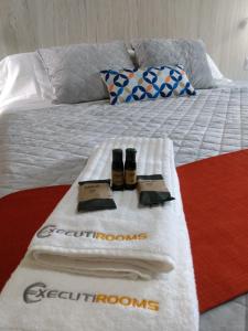 Una cama con toallas y dos botellas de conciencia. en EXECUTIROOMS VERACRUZ en Veracruz