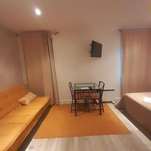 a room with a couch and a table and a tv at Villa Regio Room in Vila do Conde