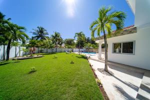 podwórko z palmami obok domu w obiekcie Casa Blanca - White House w mieście Cabarete