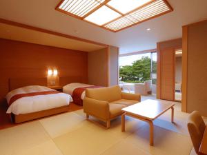 a bedroom with a bed and a bed and a chair at Jodogahama Park Hotel in Miyako