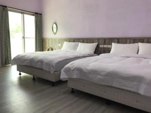 two beds sitting next to each other in a bedroom at JOY Homestay in Shoufeng