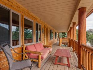 a porch of a cabin with a couch and a table at Pine Haven Resort in Estes Park