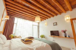 Una cama o camas en una habitación de Honglin Houseg虹林的小院 防疫整栋 古城里温馨私家小院 享受大理慢时光 树下喝茶聊天 烧烤娱乐自助厨房 休闲好去处