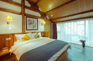Una cama o camas en una habitación de Honglin Houseg虹林的小院 防疫整栋 古城里温馨私家小院 享受大理慢时光 树下喝茶聊天 烧烤娱乐自助厨房 休闲好去处