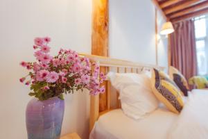 Una cama o camas en una habitación de Honglin Houseg虹林的小院 防疫整栋 古城里温馨私家小院 享受大理慢时光 树下喝茶聊天 烧烤娱乐自助厨房 休闲好去处