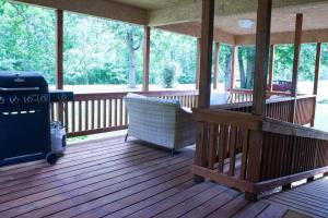a screened in porch with a grill and a chair at Home on 30 acres next to State Park in Sampson