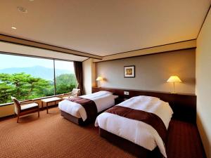 a hotel room with two beds and a large window at Jodogahama Park Hotel in Miyako