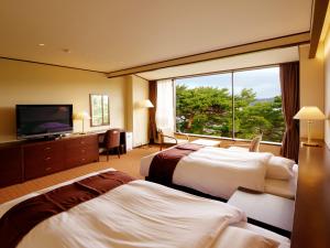 宮古市にある浄土ヶ浜パークホテルのベッド2台と大きな窓が備わるホテルルームです。