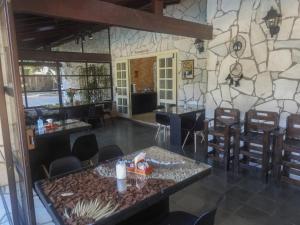 a restaurant with a stone wall and tables and chairs at Pousada Pé da Tartaruga in Teresópolis