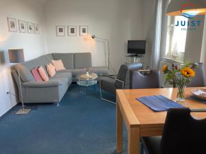a living room with a couch and a table at Haus Augusta 163 - Ferienwohnung 3 in Juist