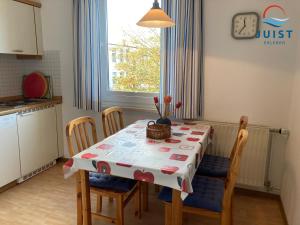 a kitchen with a table and chairs with a tablecloth on it at Haus Augusta 163 - Ferienwohnung 3 in Juist