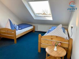 two beds in a small room with a table at Haus Augusta 163 - Ferienwohnung 3 in Juist