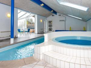 亨能史特蘭德的住宿－12 person holiday home in Henne，一座房子内带热水浴缸的大型游泳池