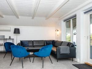 ヘンネ・ストランドにある12 person holiday home in Henneのリビングルーム(ソファ、青い椅子付)