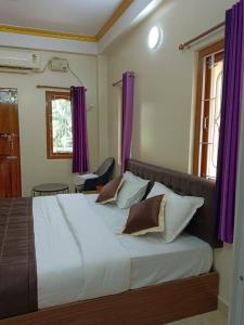 1 dormitorio con 1 cama grande y cortinas moradas en Sweet Mango Tree Homestay, en Port Blair