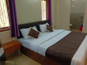 a bedroom with a large bed with purple curtains at Sweet Mango Tree Homestay in Port Blair