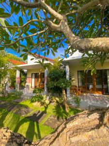 una casa con un árbol delante de ella en Gayatri Bungalows, en Nusa Penida