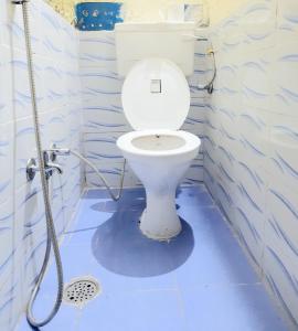 a bathroom with a toilet with a blue floor at Housetel in Jaipur