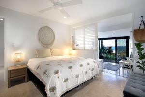 - une chambre avec un lit orné de palmiers dans l'établissement Oceana, à Bilgola