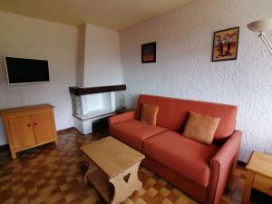 uma sala de estar com um sofá vermelho e uma televisão em Appartement Le Grand-Bornand, 2 pièces, 4 personnes - FR-1-241-241 em Le Grand-Bornand