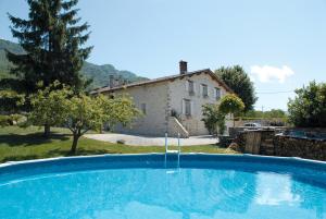 uma grande piscina em frente a uma casa em L'Estapade des Tourelons em Saint-Jean-en-Royans