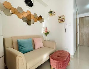 sala de estar con sofá y taburete en Sakan 5-Star Quality Condotel, en Manila