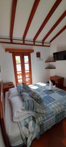 a bedroom with a bed with pillows on it at Hostal La Casita de Toñito in Villa de Leyva