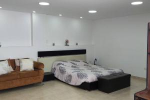 1 dormitorio con 1 cama y 1 sofá en Hermoso y amplio apartamento, Embajada Americana, en Quito