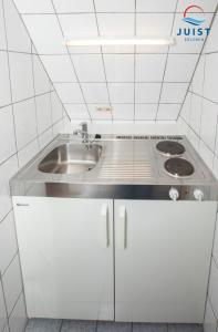 una cucina con lavello e fornello di Haus Deichgraf 176 - Wohnung 6 a Juist