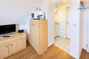 un soggiorno con TV e cucina di Haus Deichgraf 176 - Wohnung 6 a Juist 1 altra foto