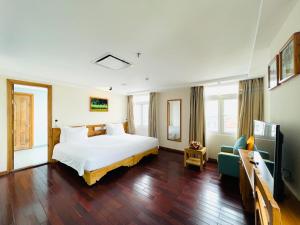 ein Hotelzimmer mit einem Bett und einem Sofa in der Unterkunft Romance Hotel in Hue