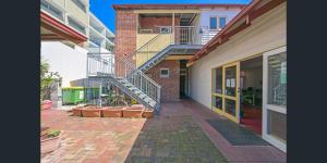 an empty courtyard of a building with a staircase at Emu Backpackers Perth - note - Valid Passport required for check in in Perth