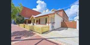 una casa con una valla delante de ella en Emu Backpackers Perth - note - Valid passport required to check in, en Perth