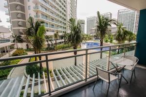 a balcony with a table and chairs and a view of a pool at AZURE Urban Resort Residences Condominium in Manila