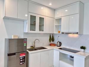a kitchen with white cabinets and a stainless steel refrigerator at căn hộ 1 ngủ có 2 giường, view hồ in Gia Lâm Pho