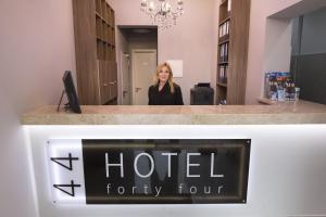 Una mujer parada frente a un hotel cuarenta y cuatro letreros en Hotel Forty Four, en Frankfurt