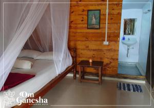 1 dormitorio con 1 cama y lavamanos. en Om Ganesha en Palolem