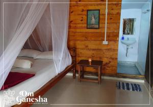 a bedroom with a bed and a sink in it at Om Ganesha in Palolem