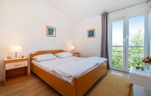una camera con un letto e una grande finestra di Apartments Mare - with parking a Bibinje (Bibigne)