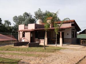 uma pequena casa com uma palmeira em frente em Lucero em Mazamitla